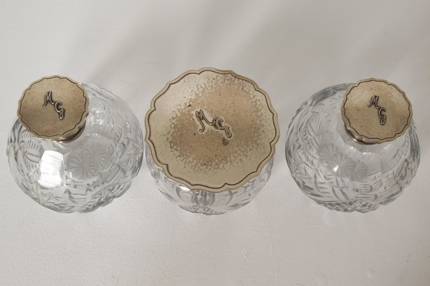 Three Silver Topped Cut Glass Bottles