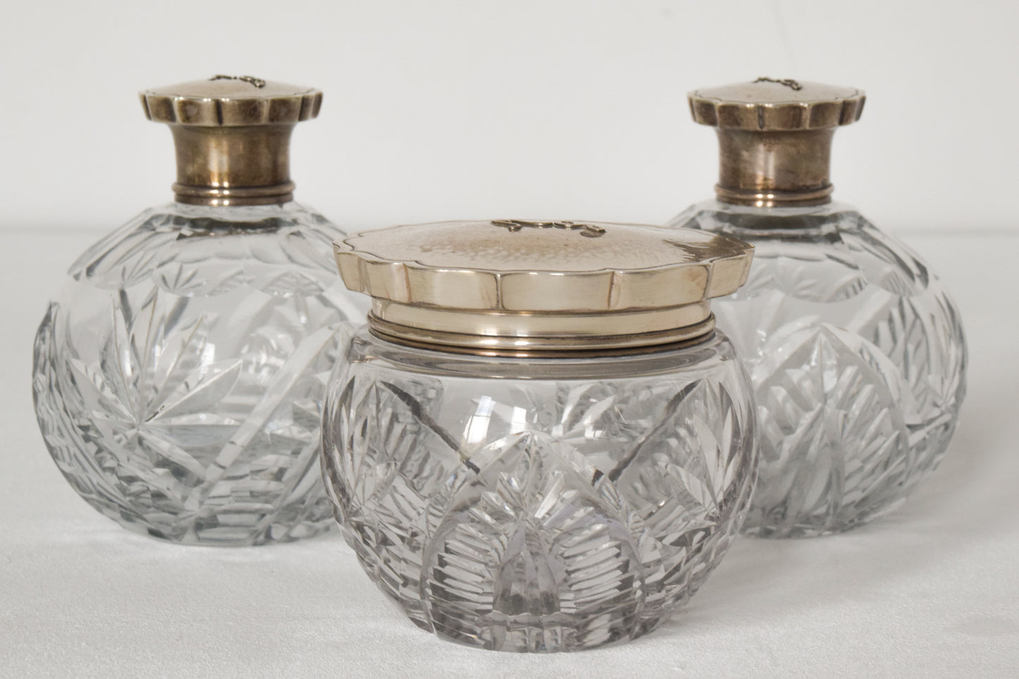 Three Silver Topped Cut Glass Bottles